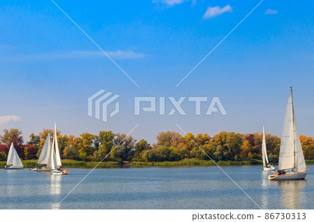 Yachts at sailing regatta on the Dnieper river in Kremenchug, Ukraine Yachts at sailing regatta on the Dnieper river in Kremenchug, Ukraine 86730313