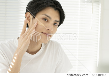 年輕人在臉頰上塗抹BB霜 男士美容 男士化妝 形象肖像 年輕人在臉頰上塗抹BB霜 男士美容 男士化妝 形象肖像 86730963