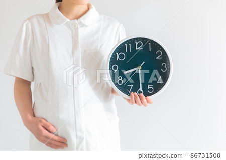 Working pregnant woman, nurse with a clock, morning and night 86731500