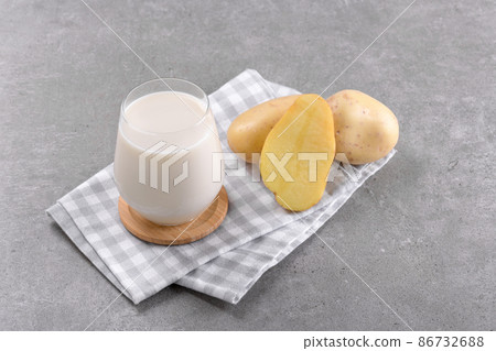 Vegan potato milk and potato on grey stone table background. Plant based alternative milk replacer and lactose free 86732688