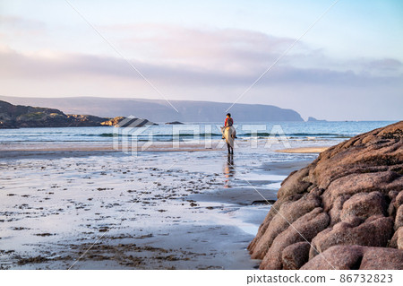 Horse riding at Cloughglass bay and beach by Burtonport in County Donegal - Ireland 86732823
