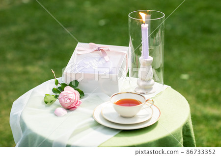 sweet cake with cup of tea and candle on table 86733352