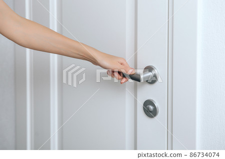 Cleaning door handles with an antiseptic wet wipe and gloves. Sanitize surfaces prevention in hospital and public spaces against corona virus. Woman hand using towel for cleaning home room door link. Cleaning door handles with an antiseptic wet wipe and gloves. Sanitize surfaces prevention in hospital and public spaces against corona virus. Woman hand using towel for cleaning home room door link. 86734074