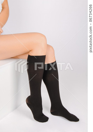 Medical Compression Stockings for varicose veins and venouse therapy. Compression Hosiery. Sock for sports isolated on white background. Black color socks mock up for advertising, branding, design. 86734266