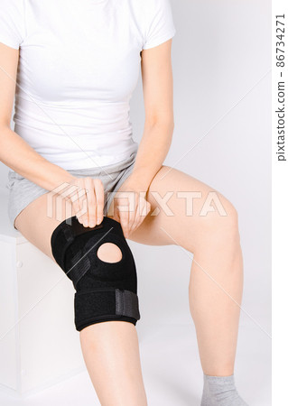 Knee Support Brace on leg isolated on white background. Elastic orthopedic orthosis. Anatomic braces for knee fixation, injuries and pain. Protective knee joint bandage sleeve. Trauma, rehabilitation. Knee Support Brace on leg isolated on white background. Elastic orthopedic orthosis. Anatomic braces for knee fixation, injuries and pain. Protective knee joint bandage sleeve. Trauma, rehabilitation. 86734271