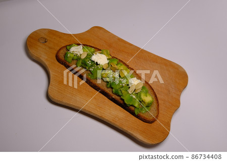 Healthy Homemade Avocado creamy Toast pumpkin seeds, creamy cheese on wooden board on isolated with background center 86734408