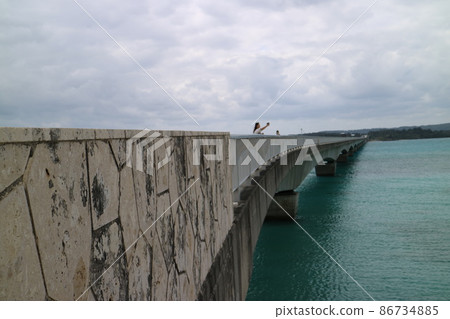 日本沖繩知名景點 古宇利大橋 橋上有一個人正在拍照 日本沖繩知名景點 古宇利大橋 橋上有一個人正在拍照 86734885