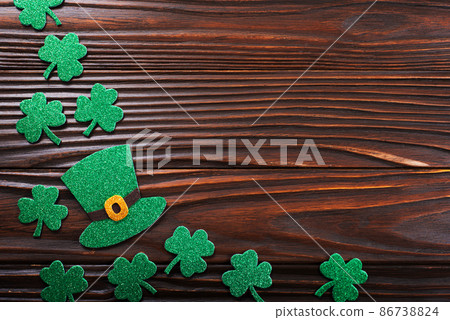 Handmade three-leaved shamrock and ivy hat on wooden background flat view 86738824