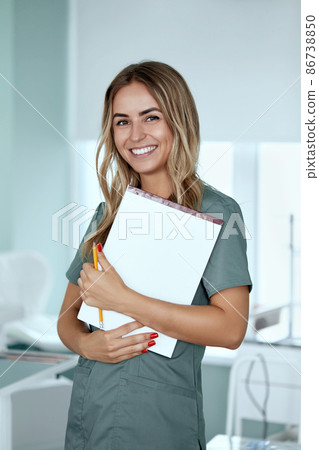 Smiling female doctor in hospital corridor. Patients consultation. Smiling female doctor in hospital corridor. Patients consultation. 86738850