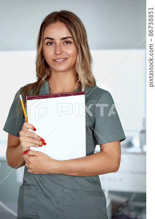 Smiling female doctor in hospital corridor. Patients consultation. 86738851