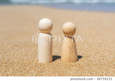 Wooden two figures of people on the sand of beach with sea view. Concept of happy couple on holiday. 86739232