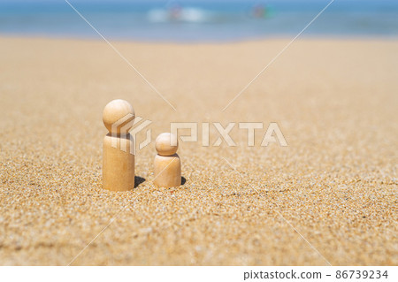 Wooden two figures of people on the sand of beach with sea view. Concept of happy children on holiday. 86739234