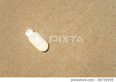 Sunscreen cream lying on sand of beach. Travel, holiday, summertime concept. Copy space. Top view. Flat lay 86739349