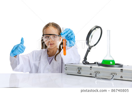 Curious child, little girl, pupil in white big gown studying, doing experiment with multicolored chemical fluid in chemistry class isolated on white background 86740805