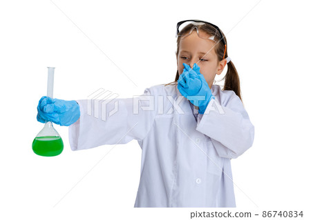 Portrait of little school girl, kid in white big gown as chemist, scientist doing experiment with multicolored chemical fluid in laboratory isolated on white background Portrait of little school girl, kid in white big gown as chemist, scientist doing experiment with multicolored chemical fluid in laboratory isolated on white background 86740834