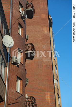 A small open balcony on the facade of a brick building. A small open balcony on the facade of a brick building. 86741855