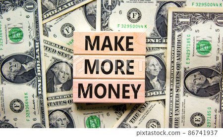 Make more money symbol. Concept words Make more money on blocks on beautiful background from dollar bills. Business, invest and make more money concept. Copy space. 86741937