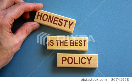 Wooden blocks form the words 'honesty is the best policy' on blue background. Male hand. Wooden blocks form the words 'honesty is the best policy' on blue background. Male hand. 86741938
