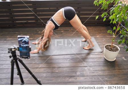 Young woman going yoga exercise at home. Health care online lessons. Indoor 86743658