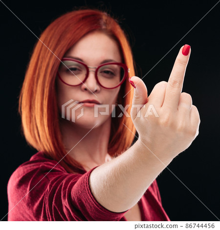 Confident and angry red haired girl showing finger 86744456