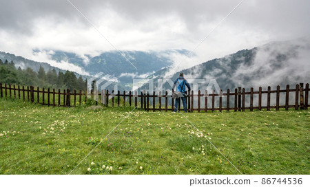 Man watching the Black Sea region mountains with clouds and dramatic skies. Green nature landscape of trees and forests in rural highlands of Black Sea Karadeniz region, Turkey Man watching the Black Sea region mountains with clouds and dramatic skies. Green nature landscape of trees and forests in rural highlands of Black Sea Karadeniz region, Turkey 86744536