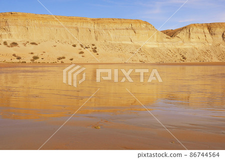 Cliffs by the beach of Pacific ocean. Puerto Santa Cruz. 86744564