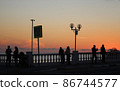 Bright sunset photo with silhouettes of people 86744577