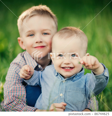 Two little brother embracing and looking at the 86744625
