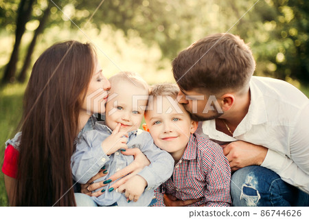Portrait of young happy family kissing his little 86744626