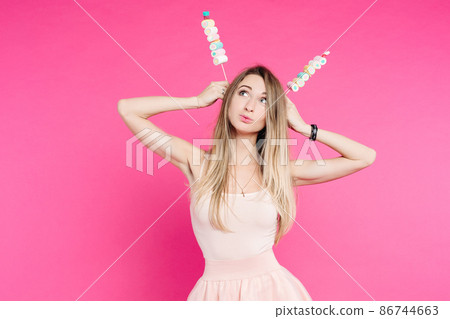 Funny girl holding marshmallows on stick under 86744663