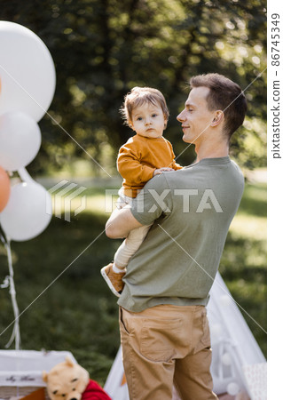 Positive father playing with his son near wigwam outdoors 86745349
