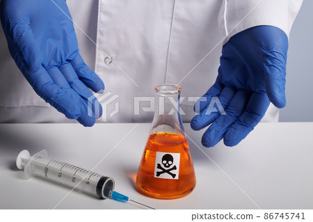 Doctor Shows Orange Poison Retort and Syringe - Labs Photo Doctor Shows Orange Poison Retort and Syringe - Labs Photo 86745741