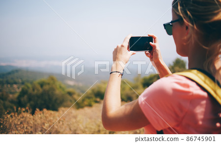 Female tourist photographing nature with cellphone Female tourist photographing nature with cellphone 86745901
