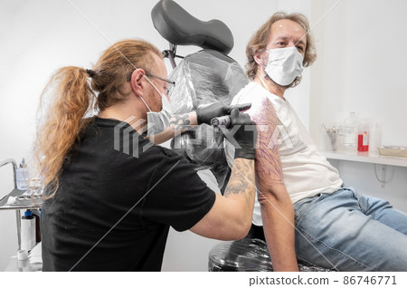 Tattoo artist making tattoo at the studio Tattoo artist making tattoo at the studio 86746771