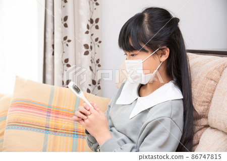 Elementary school girl who catches a cold and measures body temperature Elementary school girl who catches a cold and measures body temperature 86747815