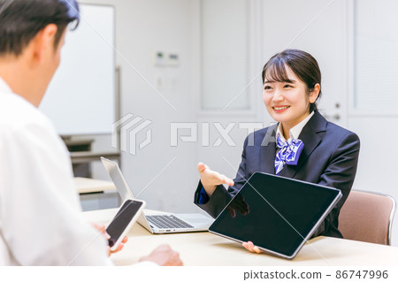 A woman (smartphone) explaining using a tablet 86747996