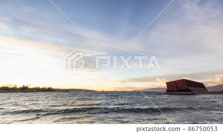 Barge container ship collided on a rocky coast during wind storm. Sunset Sky. Barge container ship collided on a rocky coast during wind storm. Sunset Sky. 86750053