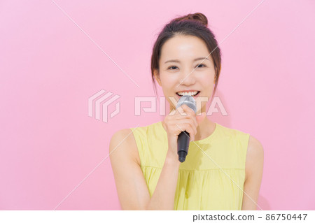 Female in her 20s with a microphone 86750447