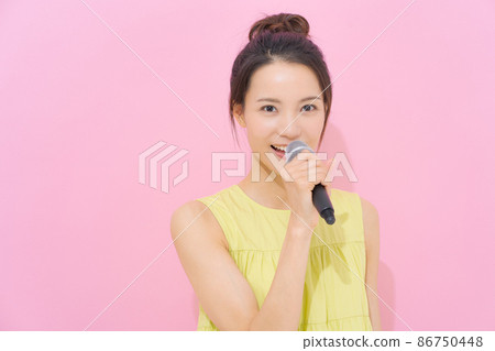 Female in her 20s with a microphone 86750448