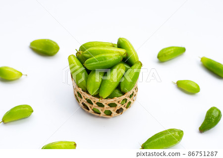 Bilimbi fruit in bamboo basket on white background. 86751287