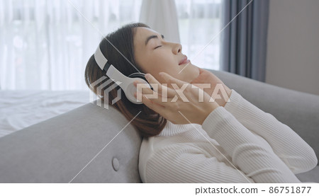 Woman wear wireless headphones enjoy good meditative music. Serene young woman in headset relax listen to audiobook with closed eyes. Woman wear wireless headphones enjoy good meditative music. Serene young woman in headset relax listen to audiobook with closed eyes. 86751877