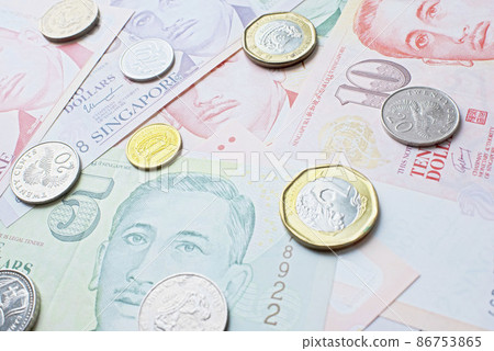Scattered Singapore dollar banknotes and coins 86753865