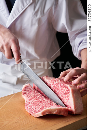 A cook who cuts sirloin steak with a kitchen knife Domestic Japanese black beef 86754390