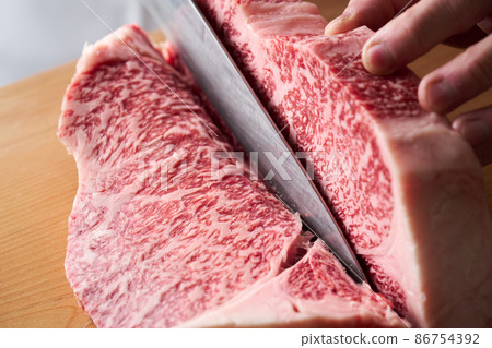 A cook who cuts sirloin steak with a kitchen knife Domestic Japanese black beef A cook who cuts sirloin steak with a kitchen knife Domestic Japanese black beef 86754392