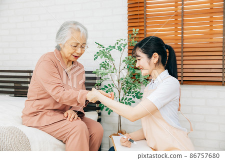測量老年婦女脈搏的女性工作人員 測量老年婦女脈搏的女性工作人員 86757680