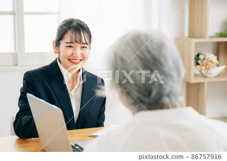 A woman in a suit and an elderly woman to have a meeting A woman in a suit and an elderly woman to have a meeting 86757916
