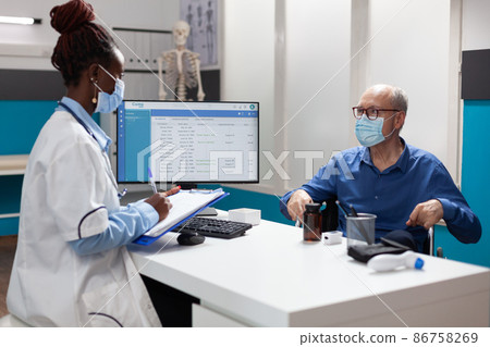 Sick senior man in wheelchair with face mask against covid19 explaining disease symptoms Sick senior man in wheelchair with face mask against covid19 explaining disease symptoms 86758269