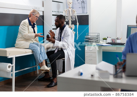 African american therapist doctor discussing sickness symptoms holding pills bottle 86758384