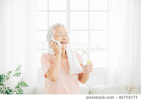 Female training at home (drinking water, smiling) Female training at home (drinking water, smiling) 86758573