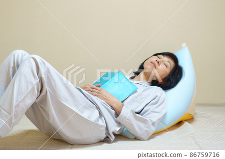 穿著睡衣的中年婦女靠在墊子上睡著了 86759716